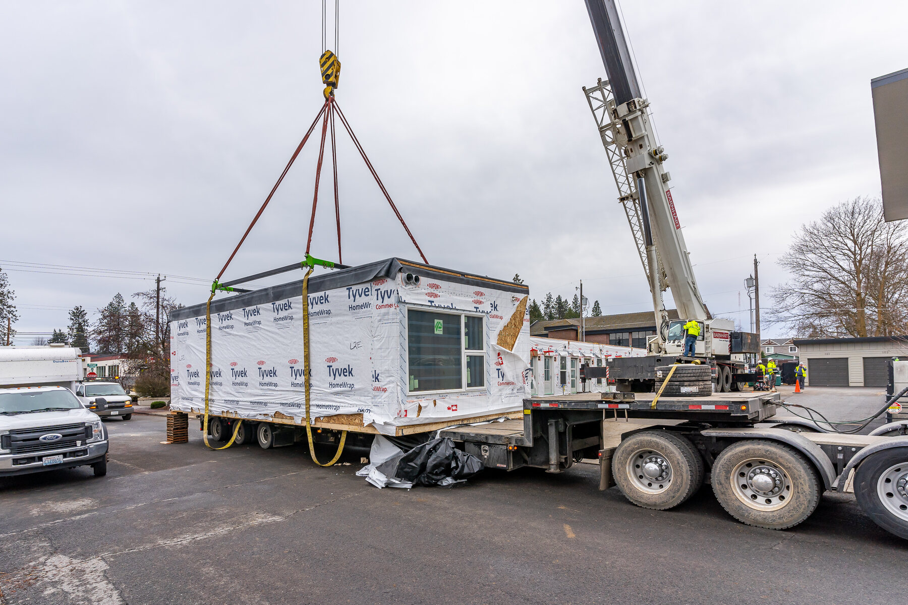 A crane setting a modular housing unit into place on a development site